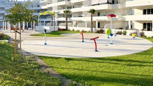 A modern building with multiple balconies and a central courtyard with grass and seating areas. - Rengue-Málagadevacaciones (Málaga)