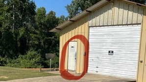 Un edificio con un'autorimessa, un segnale di divieto di parcheggio e un'antenna parabolica.