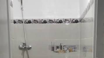 Chuveiro, toalhas de banho, sabonete, shampoo