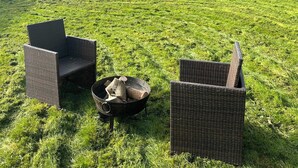 Two wicker chairs and a fire pit in a grassy field. - 2 bedroom accommodation in Quadford, near Bridgnorth (Quadford, near Bridgnorth)