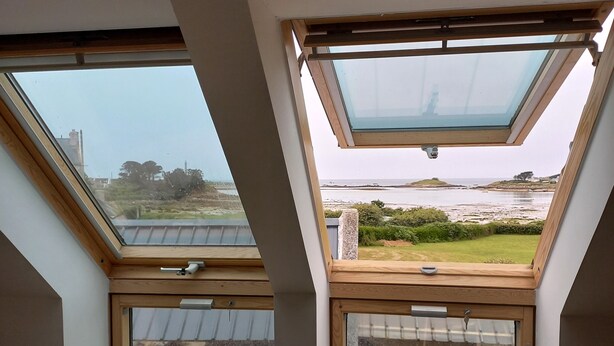 A room with two skylights offering views of a coastal landscape. - Waterfront gîte in a natural area at Lilia Plouguerneau. Sea view! (Plouguerneau)