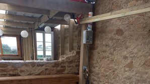 A hot tub in a rustic cabin with wooden benches and stone walls. - Waterfront gîte in a natural area at Lilia Plouguerneau. Sea view! (Plouguerneau)