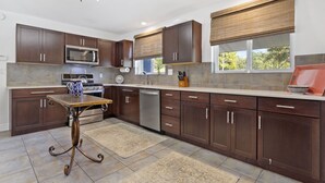 A modern kitchen with dark wood cabinets, a stainless steel microwave, and a built-in oven.