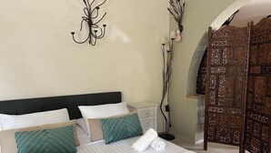 A neatly made bed with pillows, a tray with croissants, a cup of coffee, and a glass of orange juice. - Theonia Villas (Pefki)