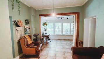 A spacious living area with a brown leather sofa, a wooden coffee table, and a hanging plant.