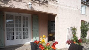 Un patio al aire libre con una mesa redonda, sillas y un florero.