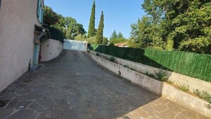 Un sendero pavimentado que conduce a un edificio con una puerta azul.