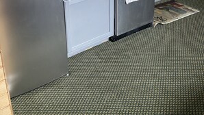 Eine kleine Küche mit Kühlschrank, Spüle und einer Arbeitsplatte.