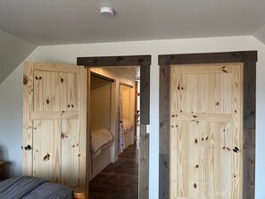 Un dormitorio con cama, mesita de noche y armario de madera.