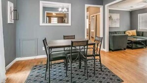A dining area with a table and chairs, a patterned rug, and a chandelier. - Oasis in Central Oklahoma City (Oklahoma City)