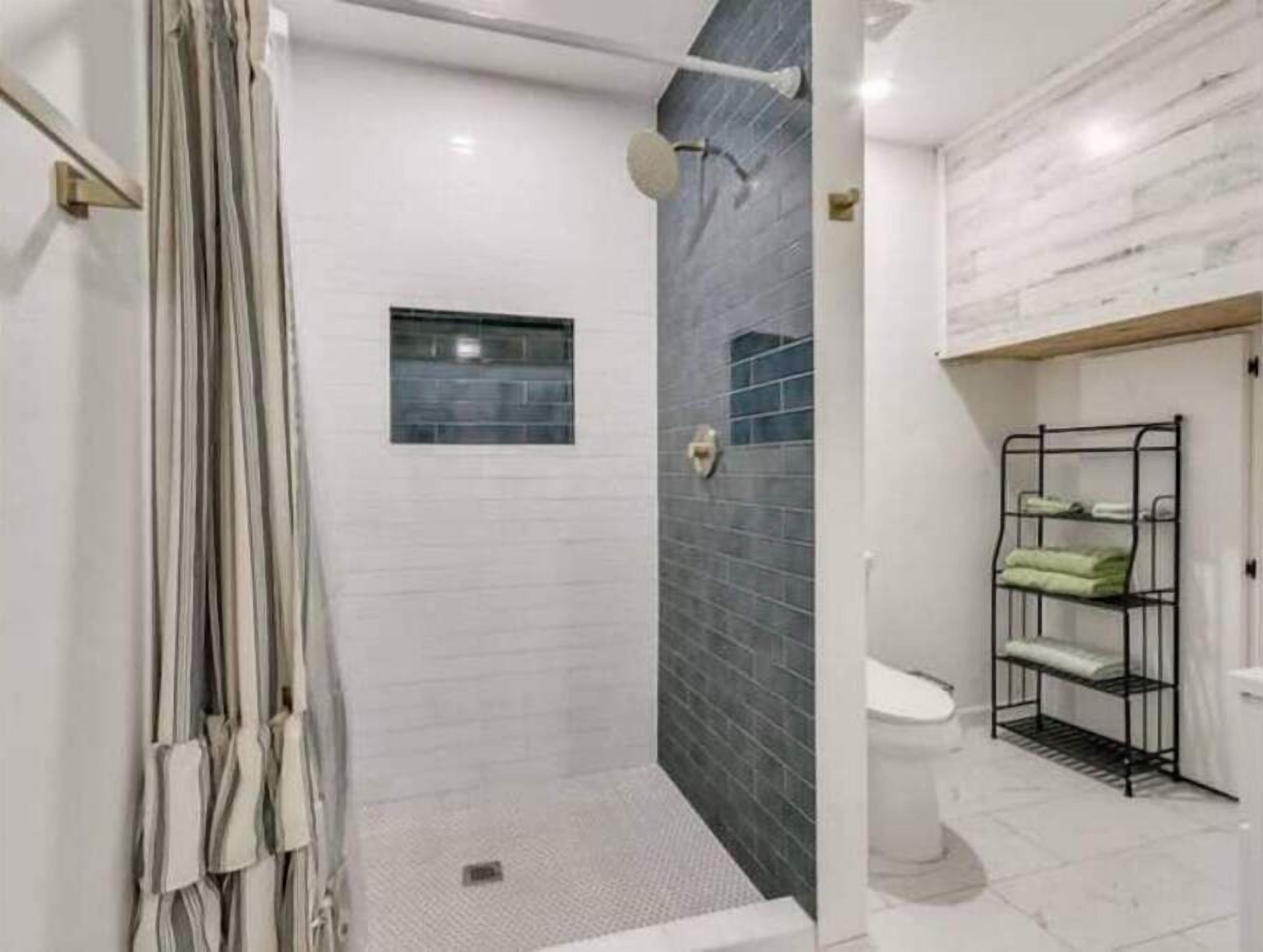 Een douche, handdoeken, zeep, toiletpapier