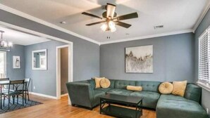 A modern living room with a sectional sofa, a coffee table, and hardwood flooring. - Oasis in Central Oklahoma City (Oklahoma City)