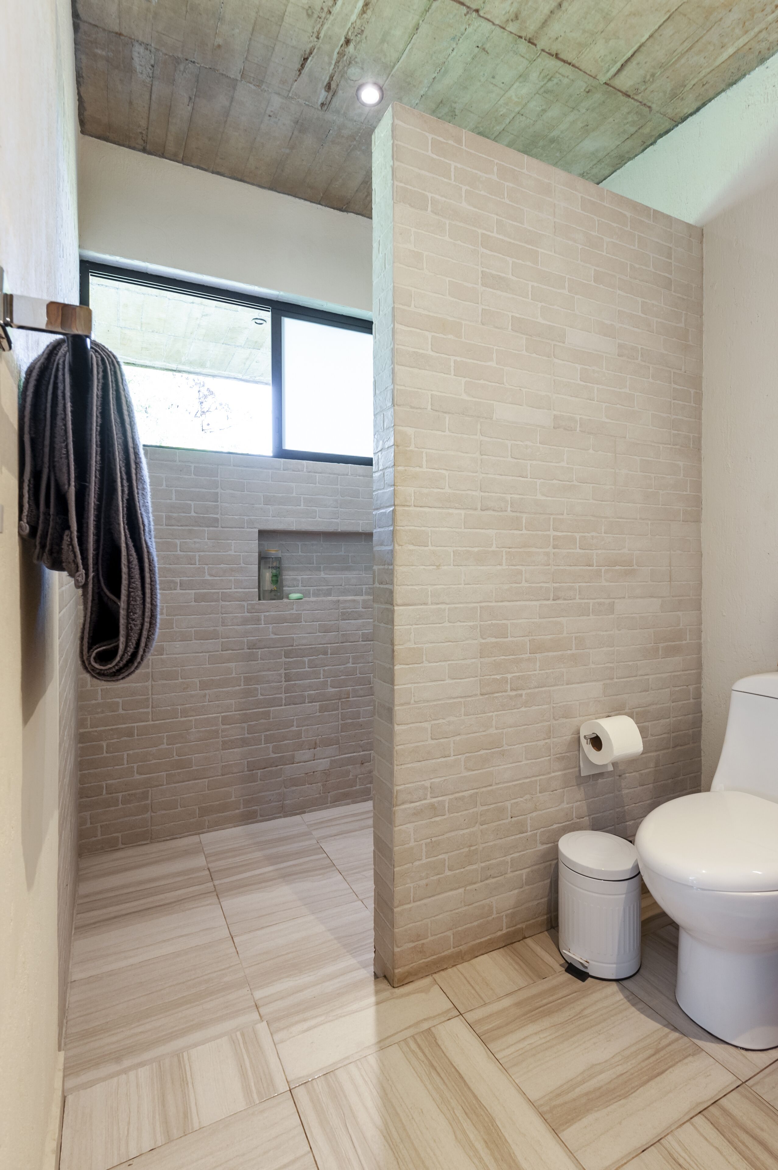 Une salle de bain équipée d’une douche, de toilettes et d’un porte-serviettes.
