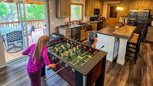 Una cocina amplia con mesa de fútbol, armarios de madera y una isla grande.