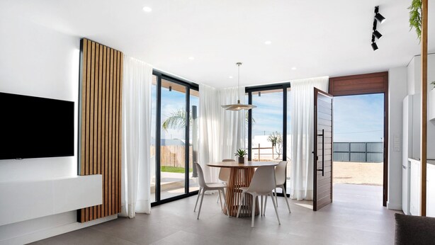A modern living room with a flat-screen TV, a dining area with a round table, and large sliding glass doors leading to a balcony. - Holiday Home 'Casa Adriana' with Private Pool, Wi-Fi and Air Conditioning (Conil de la frontera)