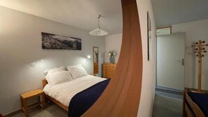 Ein Schlafzimmer mit einem Bett, einem Nachttisch und einem hölzernen Kopfende.