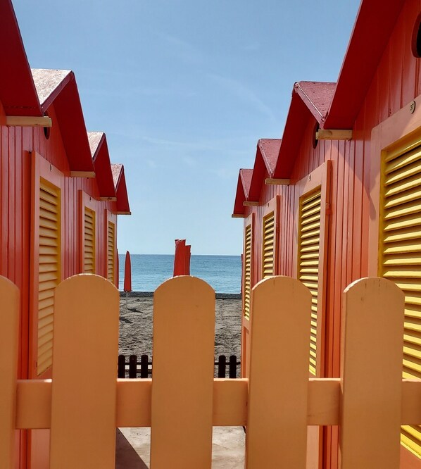Une rangée de cabanes de plage offrant une vue dégagée sur la mer.