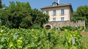 A large, two-story building with a stone wall and a large arched entrance. - LE Pinot - Porte-de-savoie (PORTE-DE-SAVOIE)