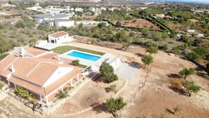 Un quartier résidentiel doté d’une piscine, de bâtiments blancs et d’un paysage vallonné.