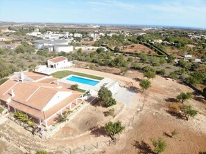 A residential area with a swimming pool, white buildings, and a hilly landscape. - Villa 'Monte Do Pataco' with Private Pool, Private Terrace and Wi-Fi (Albufeira)