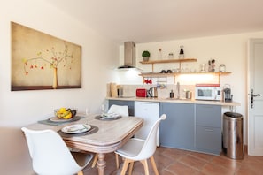 Une cuisine moderne avec une table à manger, des chaises et un four à micro-ondes.