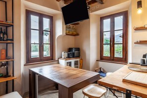 Une cuisine compacte avec une table en bois, un four à micro-ondes et une machine à café.