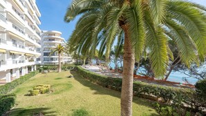 Un hôtel doté d’une piscine, de palmiers et offrant une vue dégagée sur la mer.