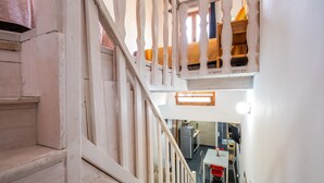 A staircase leading to a kitchen area with a dining table and chairs.