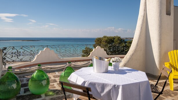 A terrace with a table set for dining, overlooking a coastal view. - Holiday Home 'Villa Gaudì - Milà' with Private Terrace, Wi-Fi and Air Conditioning (Sant'Isidoro)