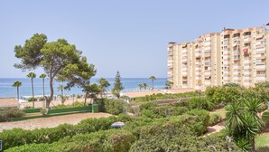 A coastal residential area with a tall building, greenery, and a clear view of the sea. - Apartment 'Primera Línea con Terrace A104' with Sea View, Shared Pool and Wi-Fi (Torrox)