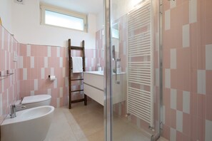 Une salle de bain comprenant des toilettes, un lavabo et un espace douche.