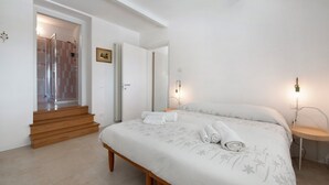 A bedroom with a bed, a bedside table, a lamp, a door leading to a bathroom, and a staircase. - Apartment "Casa Mavi" with Shared Terrace, Wi-Fi & Air Conditioning (Corte Franca)
