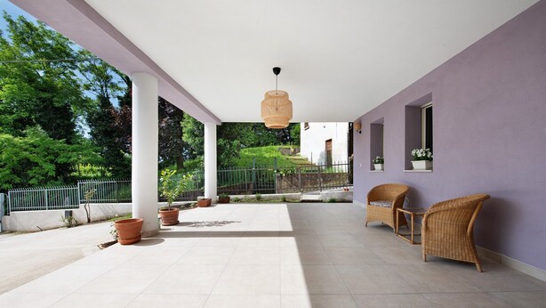 A covered outdoor area with tiled flooring, wicker furniture, and potted plants. - Apartment "Casa Mavi" with Shared Terrace, Wi-Fi & Air Conditioning (Corte Franca)