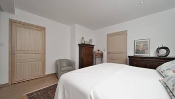 Una camera da letto con un letto, una sedia, una cassettiera e un armadio.