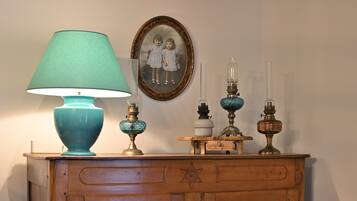 Et trækommode med en teal-farvet lampe, et indrammet fotografi og flere dekorative genstande.