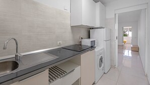 A modern kitchen with a stainless steel sink, a microwave, and a built-in washing machine. - Vacation Apartment 'Costa Del Silencio Tenerife Sur' with Shared Pool and Wi-Fi (Arona)