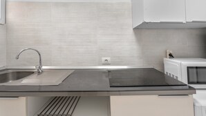 A modern kitchen with a stainless steel sink, a black countertop, and a built-in microwave. - Vacation Apartment 'Costa Del Silencio Tenerife Sur' with Shared Pool and Wi-Fi (Arona)