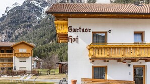 Un edificio con un cartel que dice 'Gartner Hof' y un balcón con barandillas de madera.