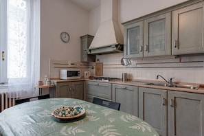 A kitchen with a stove, microwave, sink, and cabinets.