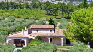 A villa with a tiled roof, a covered patio with outdoor furniture, and a view of a mountainous landscape. - Luxurious home in Mouries with private swimming pool, can be inside or outside (Mouries)