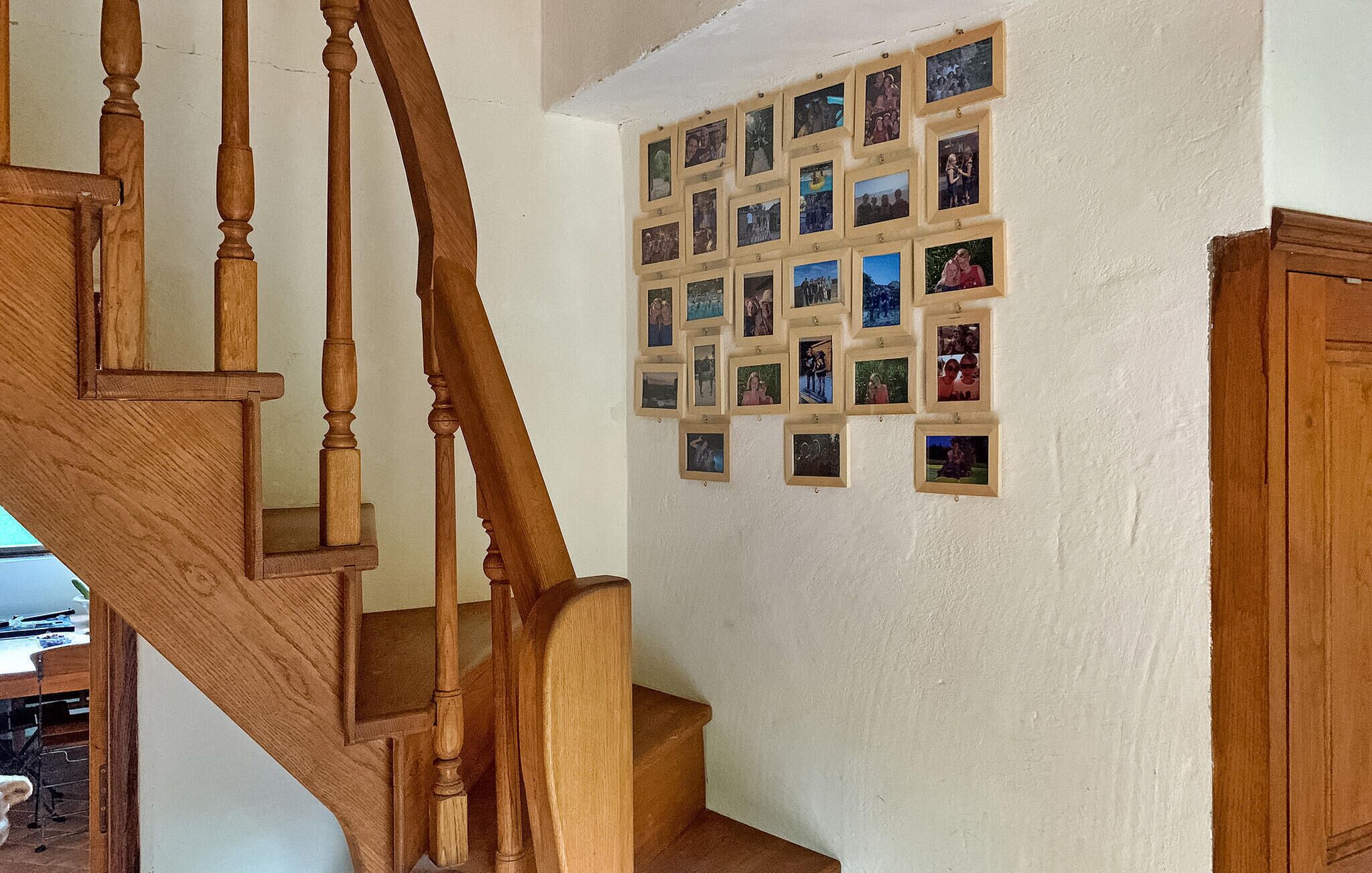 A wooden staircase with a wall of framed photographs.