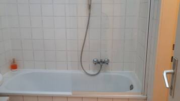 Ein Badezimmer mit Badewanne, Dusche und Toilette.