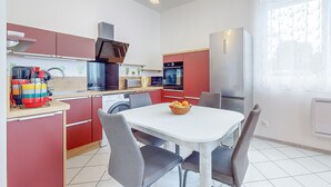 Una cocina compacta con comedor, que incluye microondas, horno y refrigerador.