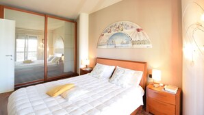A hotel room with a bed, a nightstand, a lamp, a wall-mounted artwork, and a sliding door. - Awesome home in Bergamo with WiFi (Bergamo)