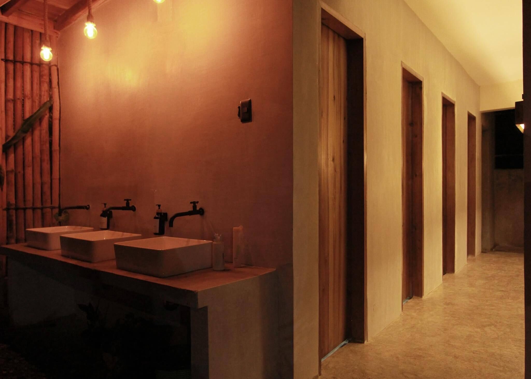 Un bagno moderno con due lavabi, uno specchio e una scala in legno.