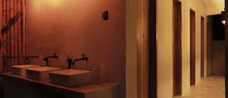 A modern bathroom with two sinks, a mirror, and a wooden staircase.