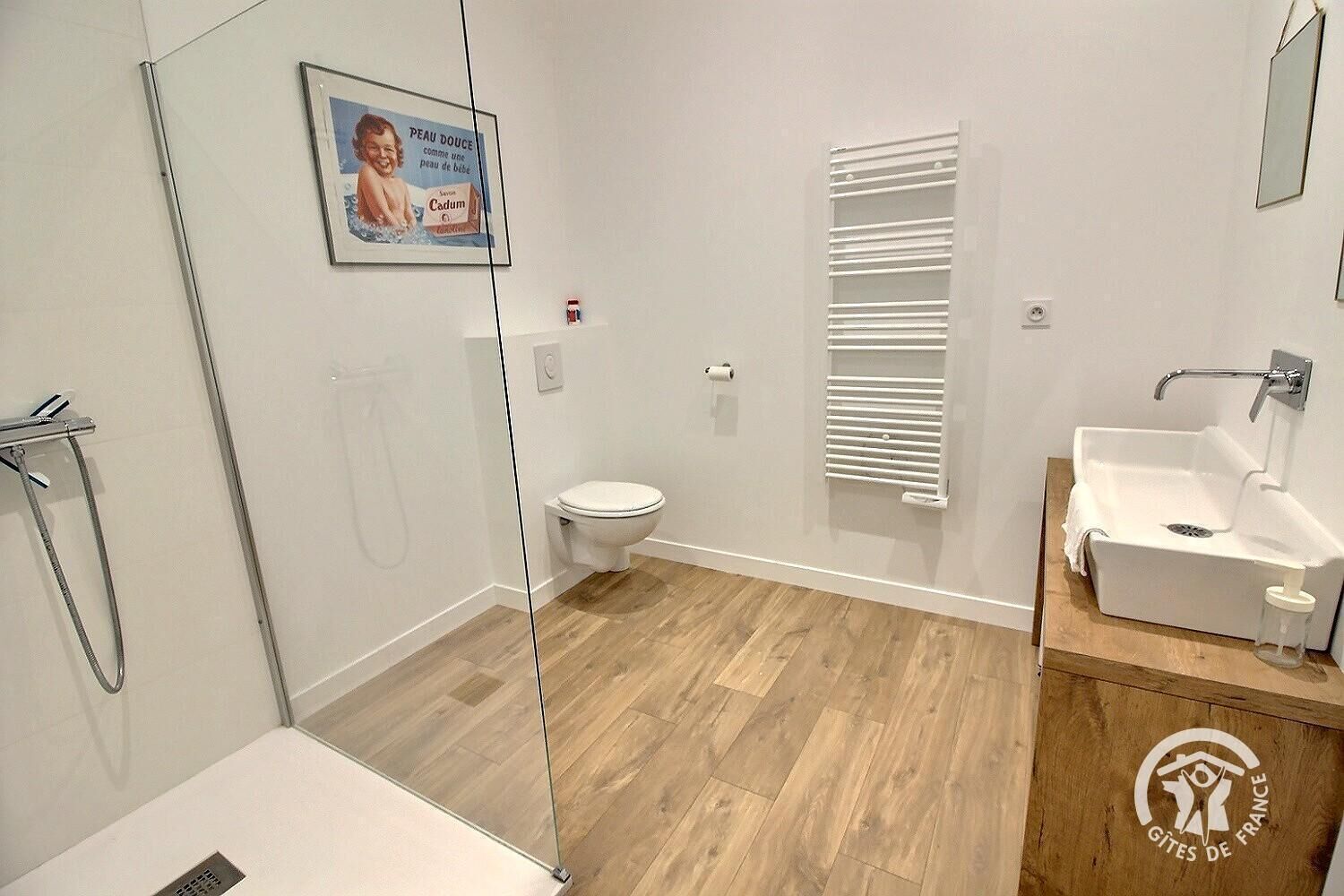 A modern bathroom with a shower, toilet, and sink.
