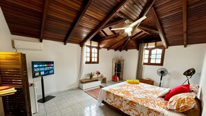 A bedroom with a bed, a TV, a ceiling fan, and a window. - Le Domaine du Val de l'Orge (Vieux-Habitants)