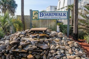 Señal de Boardwalk en 1100 FT. Pickens Rd., con una cascada pequeña y rocas.