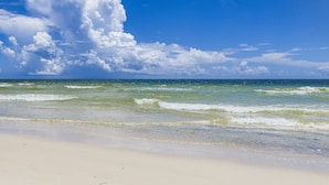Ein Strand mit klarem Himmel und Wellen.